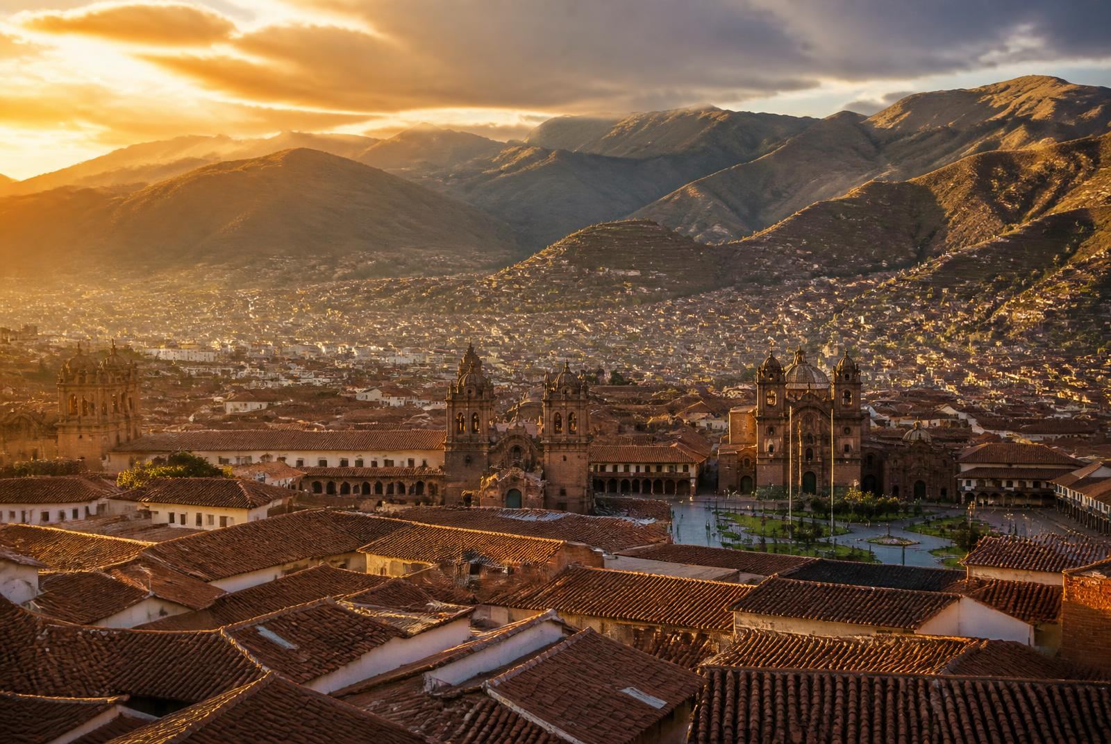Vista da cidade de Cusco ao entardecer, com telhados de terracota e os Andes ao fundo